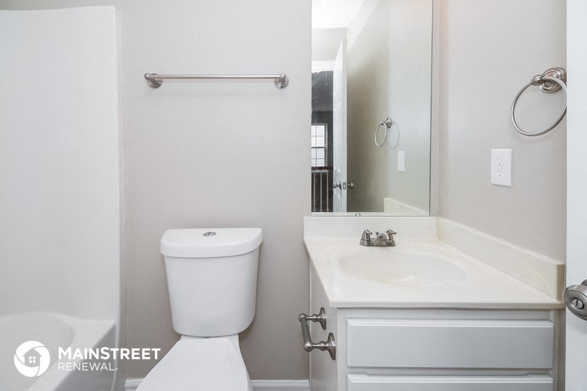 a bathroom with a toilet and a sink and a mirror