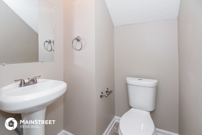 a bathroom with a toilet and a sink and a mirror