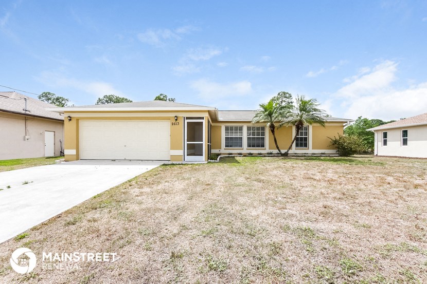 a yellow house with a yard and a white garage door