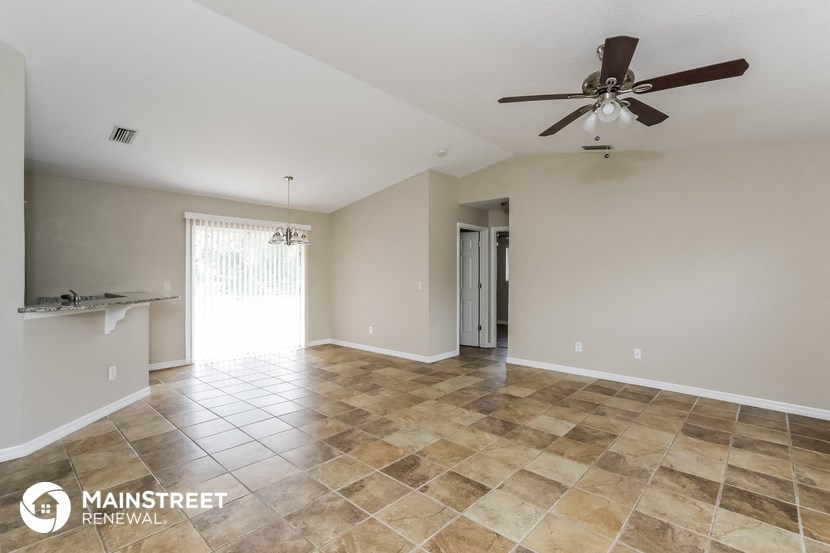 the living room and dining room are spacious with tile floors and a ceiling fan