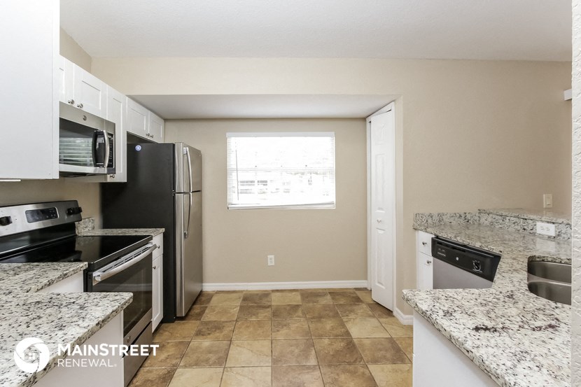 the kitchen has granite counter tops and stainless steel appliances