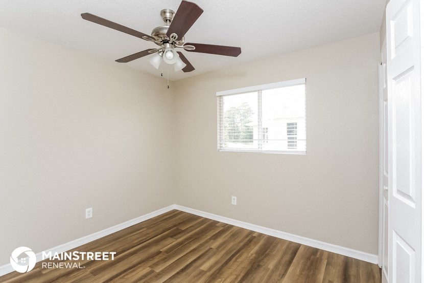the living room has a ceiling fan and hardwood floors