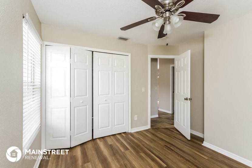 the living room of a renovated apartment with a ceiling fan