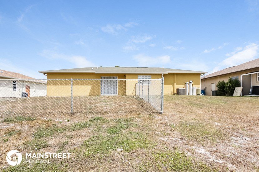 a fenced in yard in front of a house