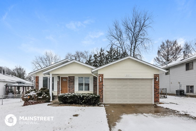a home in the snow with a garage door