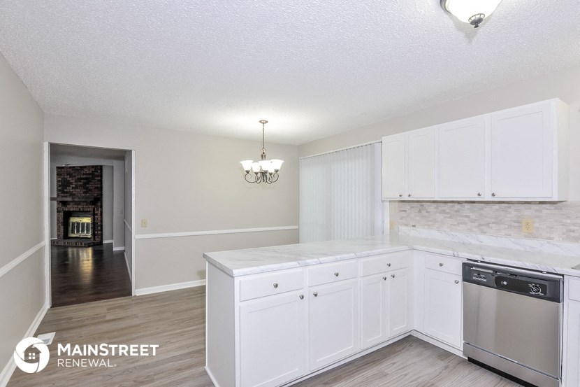 a kitchen with white cabinets and a stainless steel dishwasher