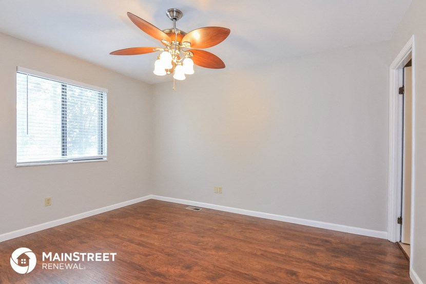 a bedroom with a ceiling fan and a window