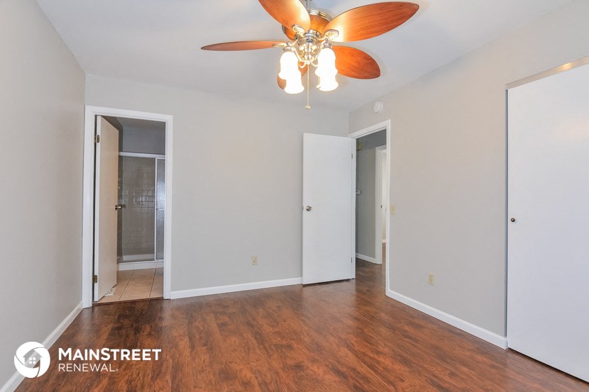 a living room with wood flooring and a ceiling fan