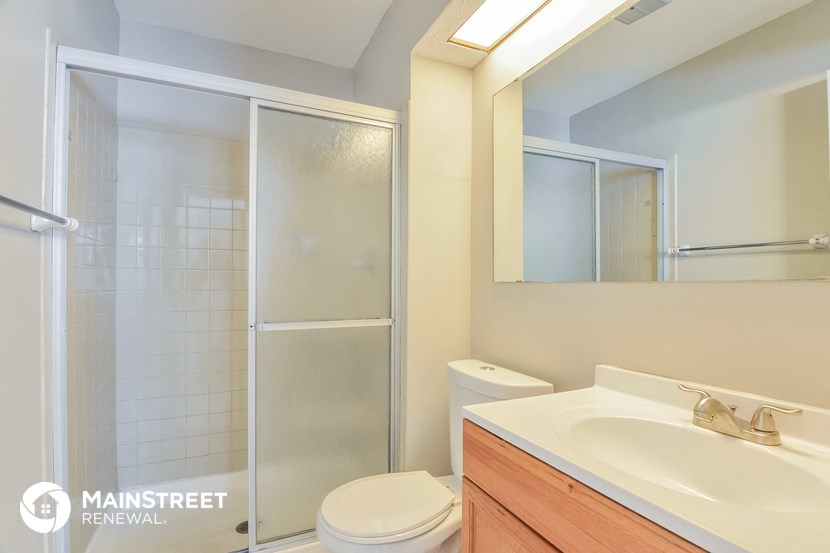 a bathroom with a shower and a sink and a toilet