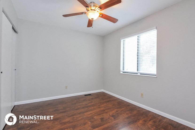 the bedroom with wood flooring and a ceiling fan