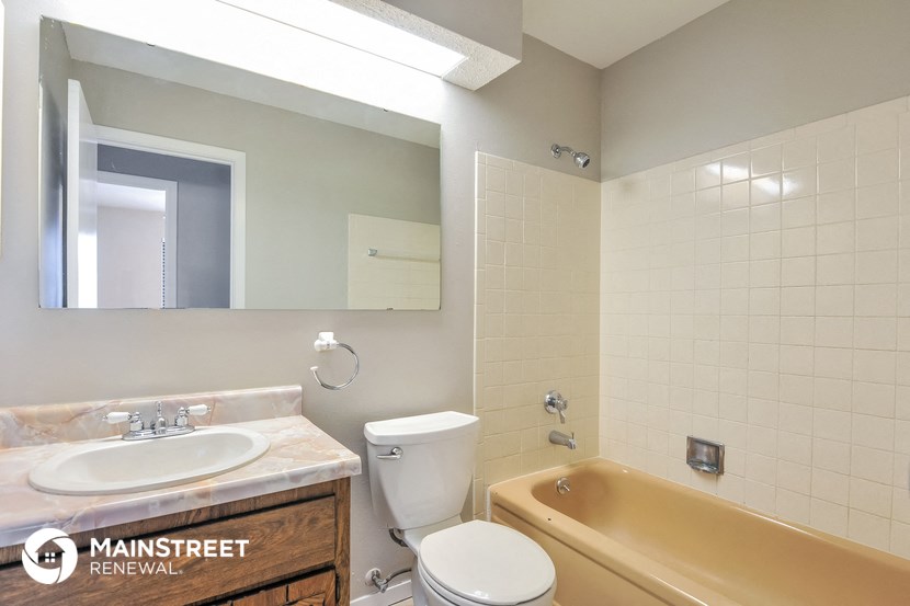 a bathroom with a toilet sink and tub and a mirror