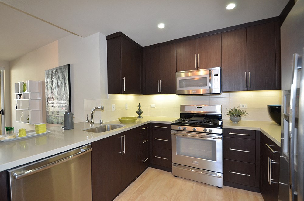 a modern kitchen with stainless steel appliances and wooden cabinets