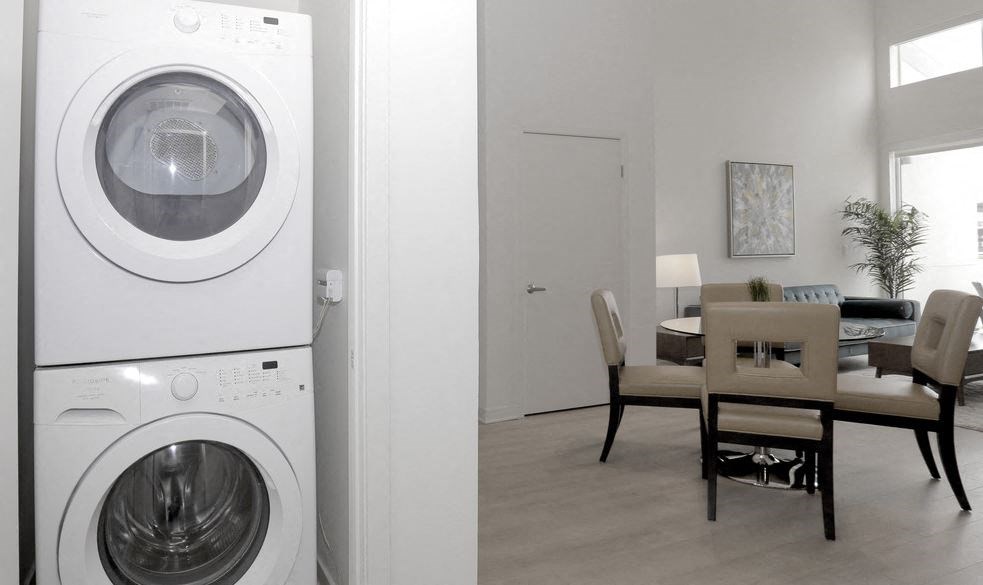 a washer and dryer in a living room next to a dining room table
