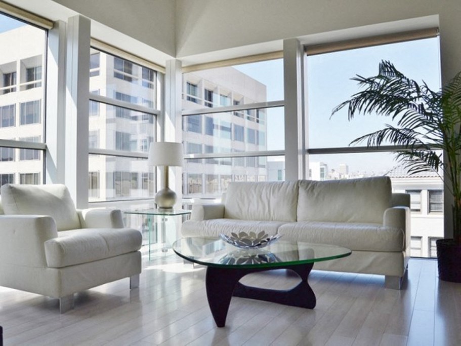 a living room with a couch and a coffee table in front of large windows