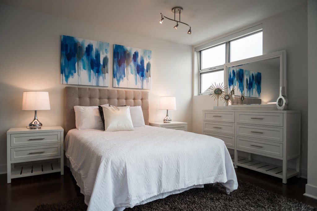 a bedroom with a large bed and paintings on the wall