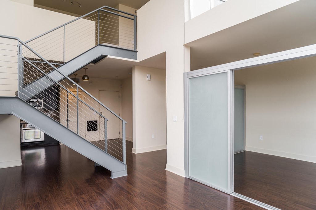 a living room with a staircase and a glass door