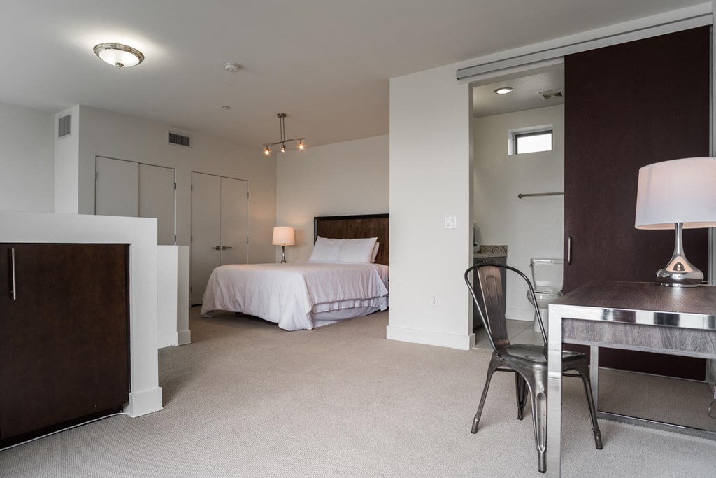 a bedroom with a bed and a desk in a hotel room