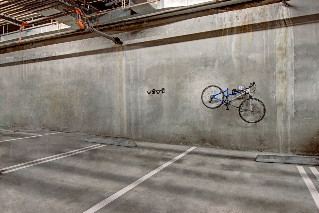a bike hanging on a wall in a parking garage