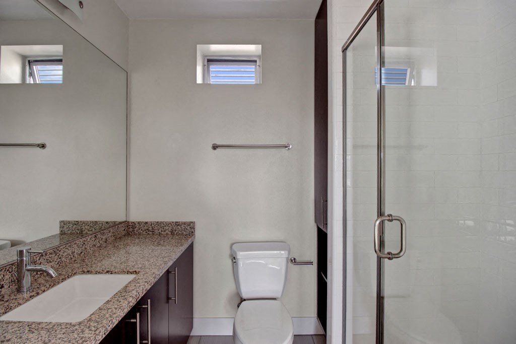 a bathroom with a toilet and a sink and a shower