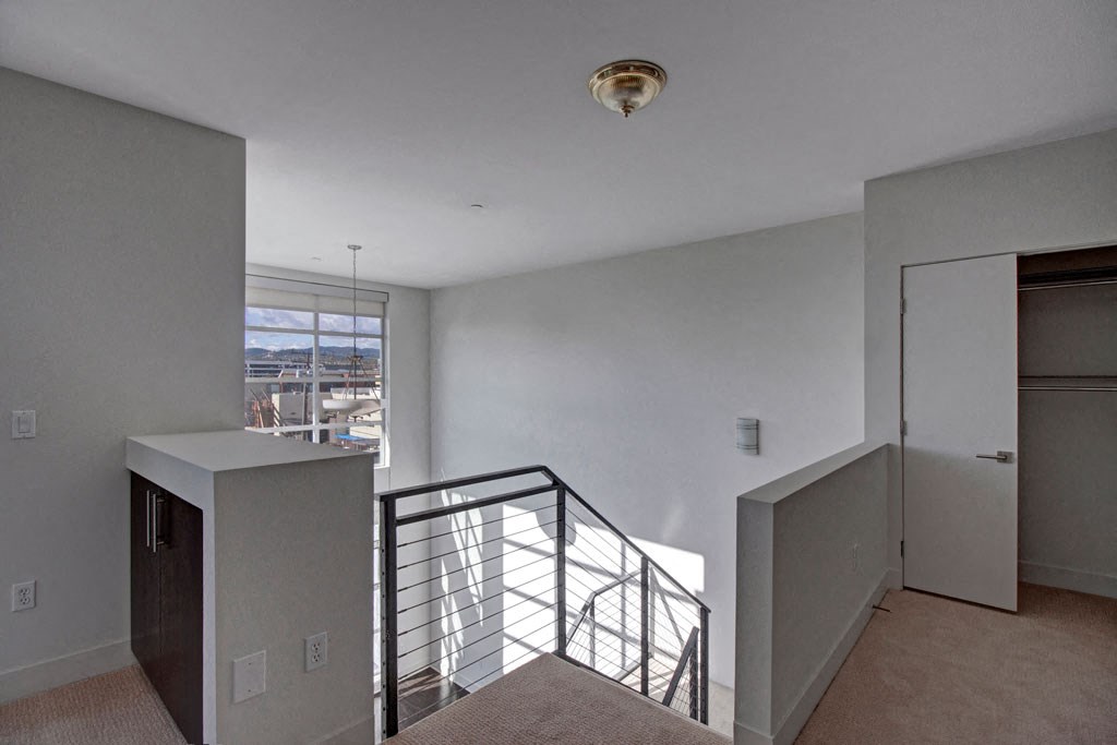the view from the top of a staircase in a home with white walls and a