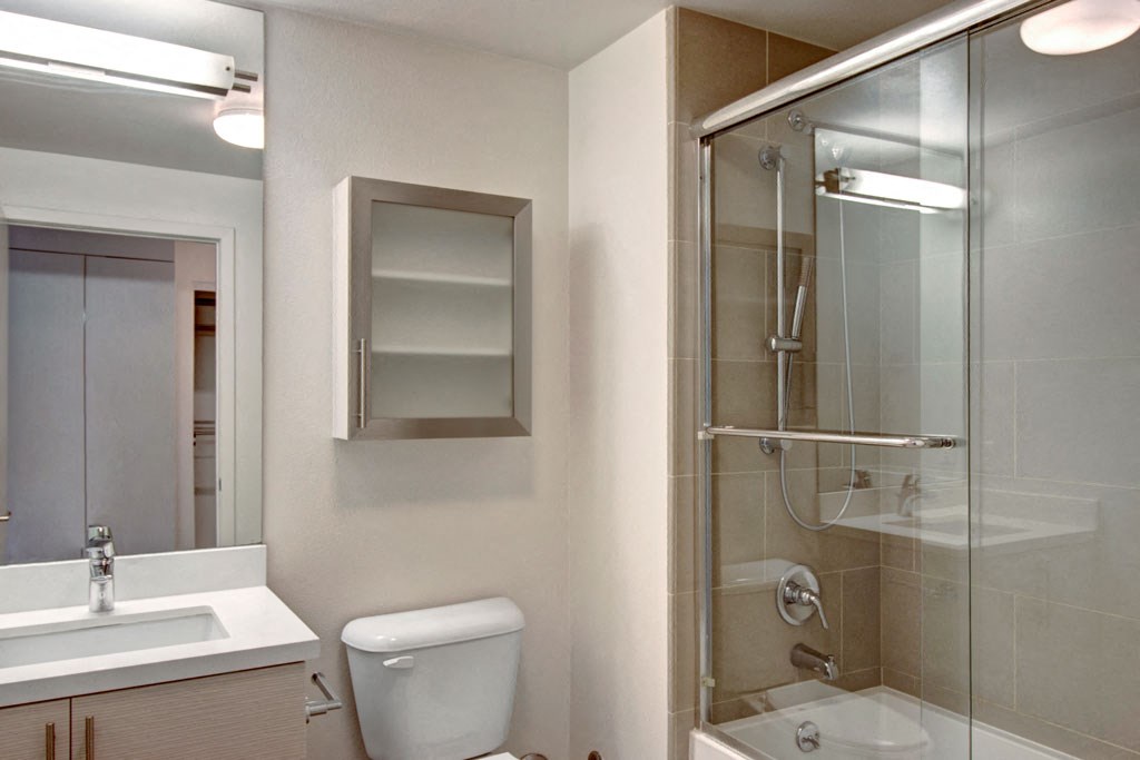 a bathroom with a shower and a sink and a toilet
