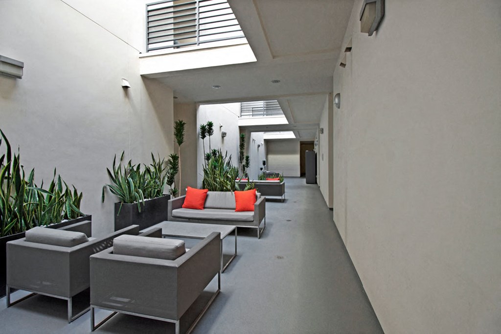 a long corridor with couches and potted plants