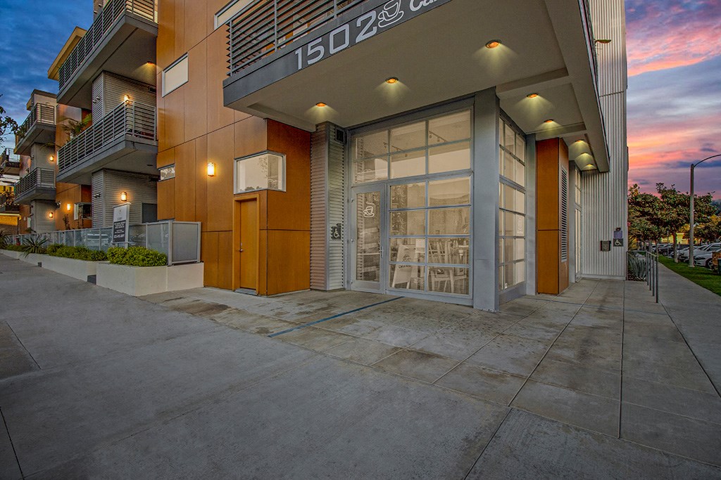 a building with a glass door and a sunset in the background