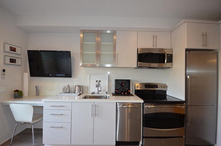 a kitchen with white cabinets and stainless steel appliances