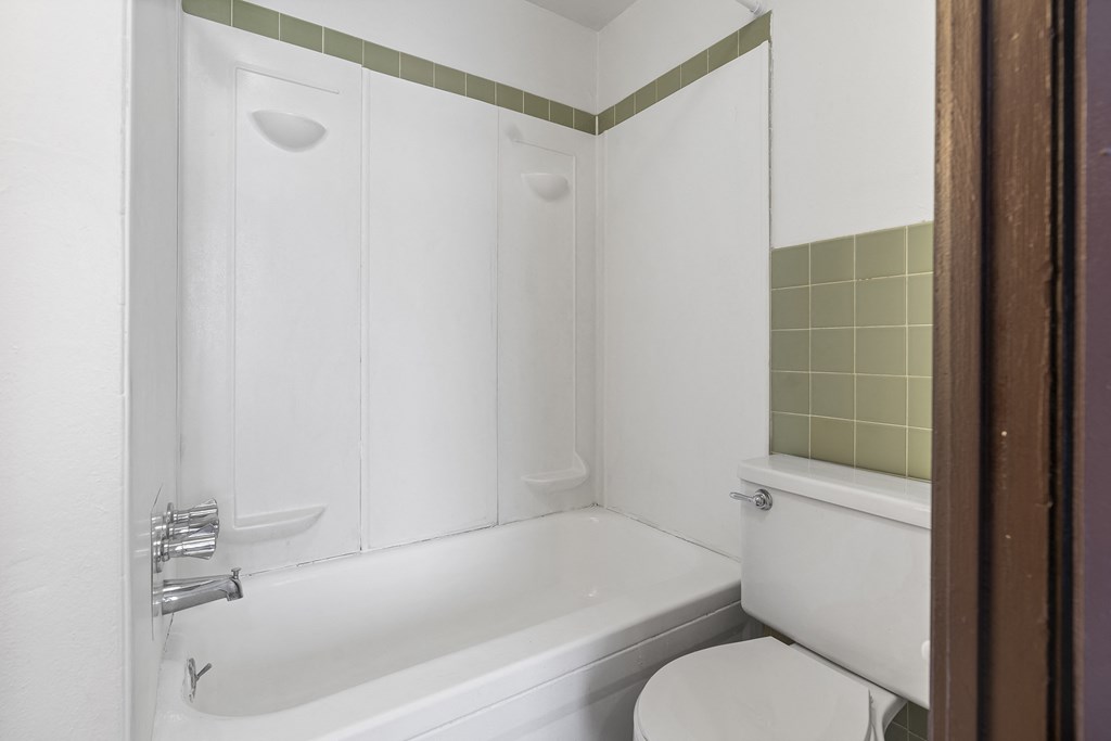 a white bathroom with a tub and a toilet