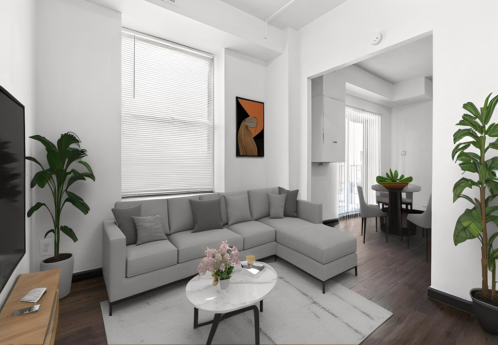 a living room with a gray couch and a white table