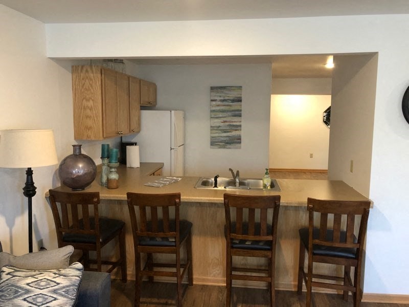 a kitchen with a bar with four chairs