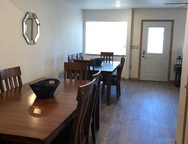 a dining room with a wooden table and chairs