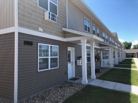 a building with a porch and a sidewalk in front of it