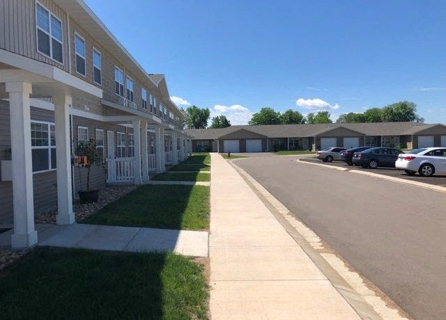 a sidewalk in front of a row of houses