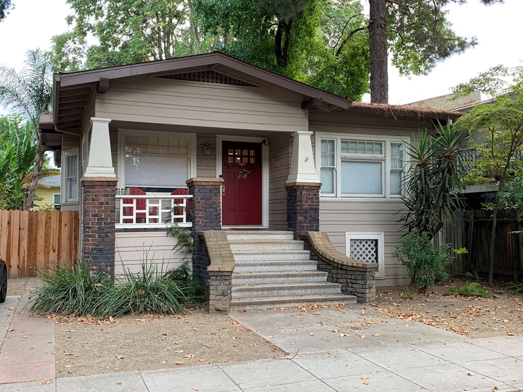 a small house with a red door and stairs