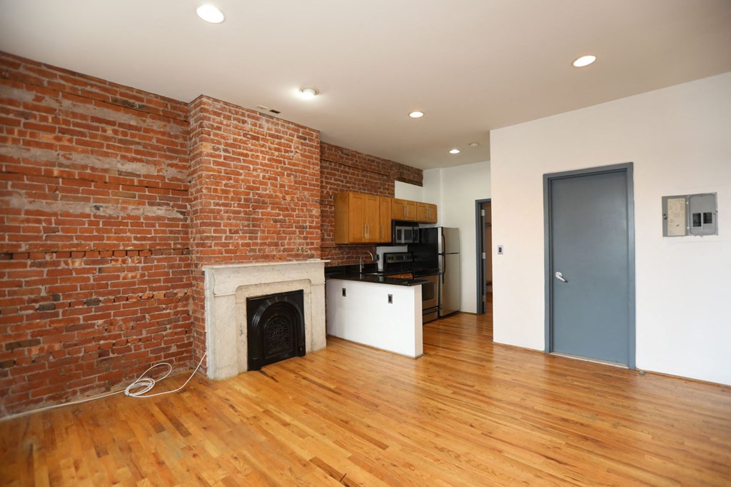 a living room with a brick wall and a fireplace