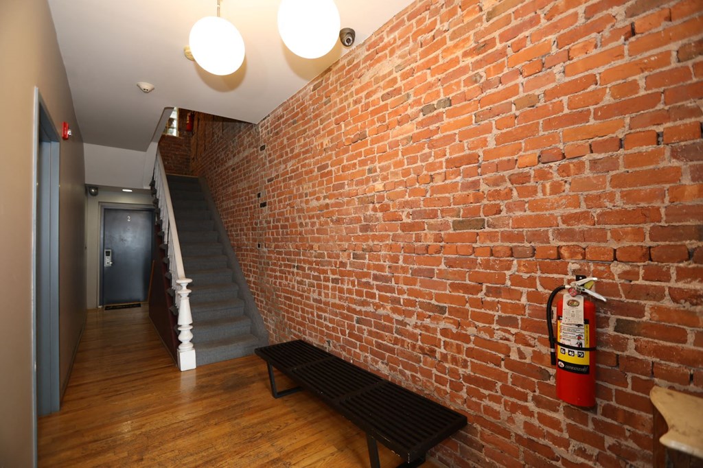 a brick wall with a fire hydrant and a bench