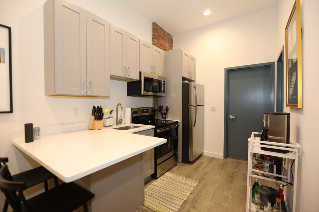 a kitchen with a white counter top and a refrigerator