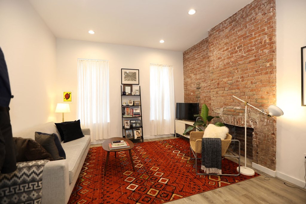 a living room with a brick wall and a couch