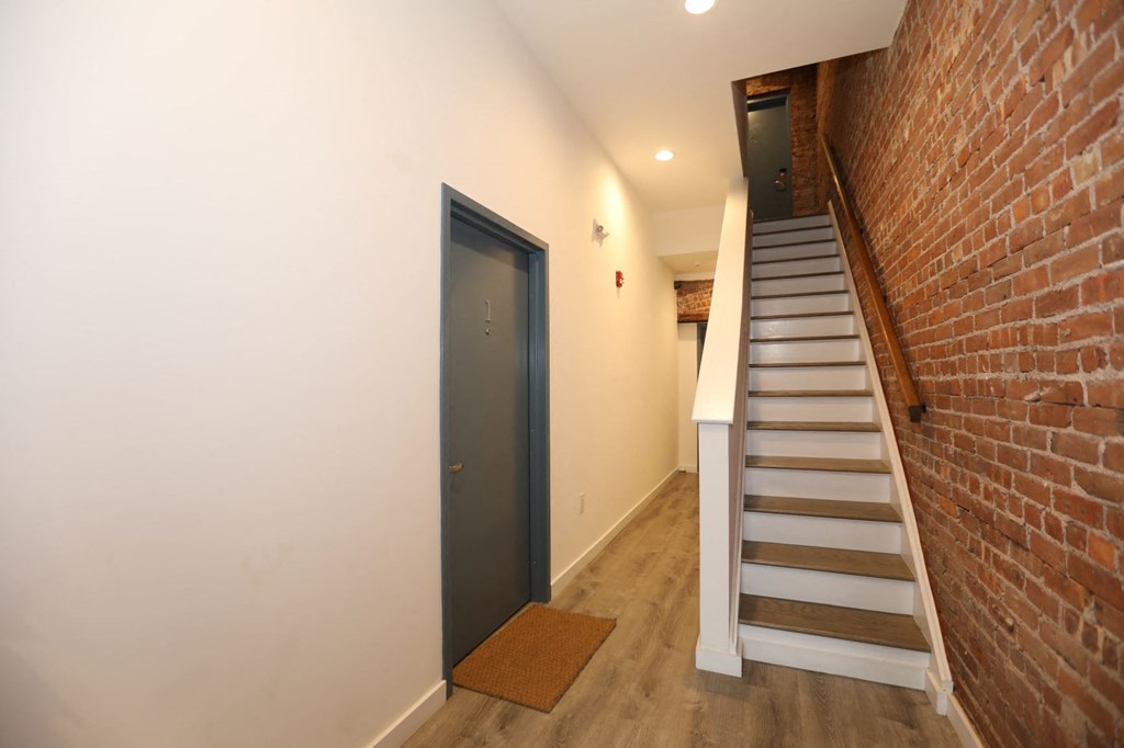 a staircase and brick wall in a room with a door