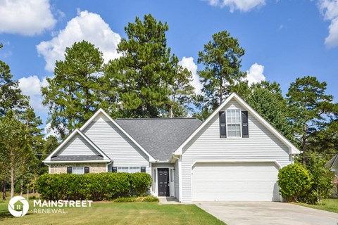 a white house with a lawn and trees in front of it