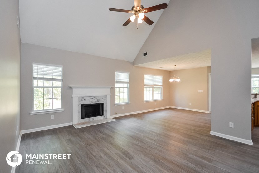 the living room with fireplace and ceiling fan