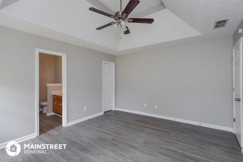 an empty living room with a ceiling fan
