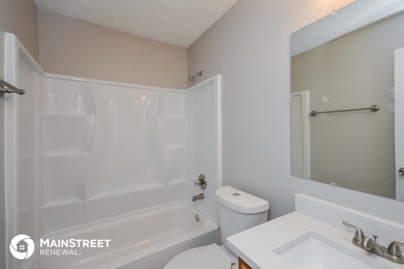 a white bathroom with a tub and a sink and a toilet