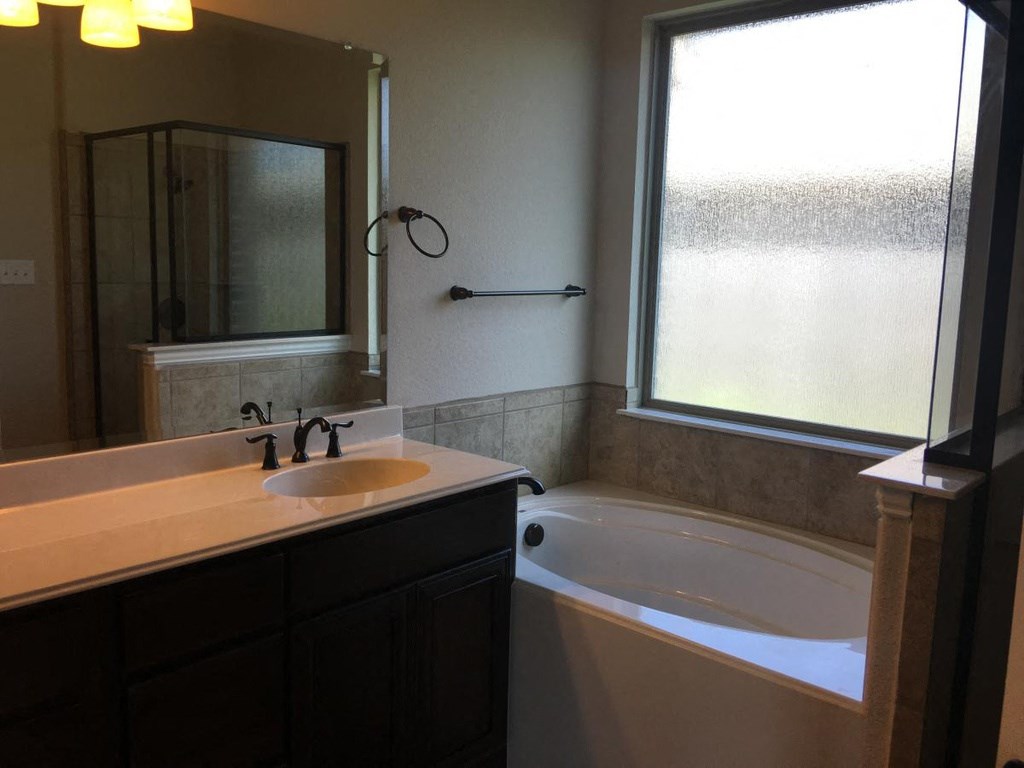 a bathroom with a sink and a tub and a window