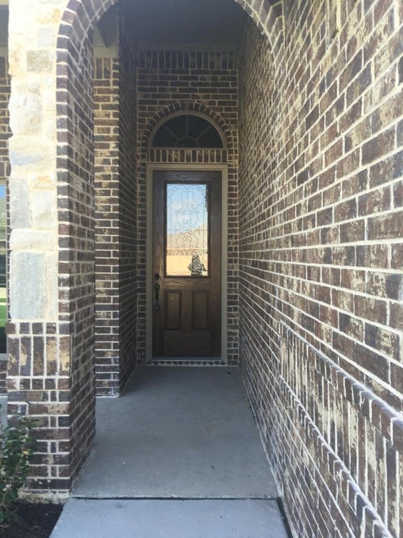 the front door of a brick building with a porch