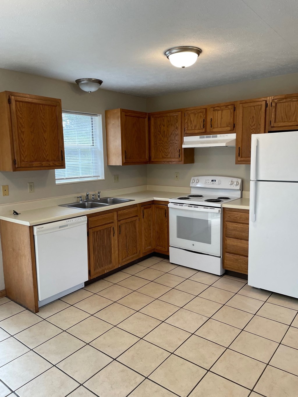 a kitchen with white appliances and wooden cabinets