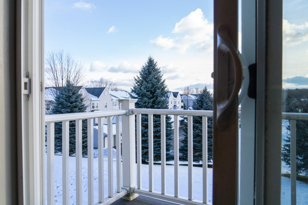 a view of a balcony in the snow from a window