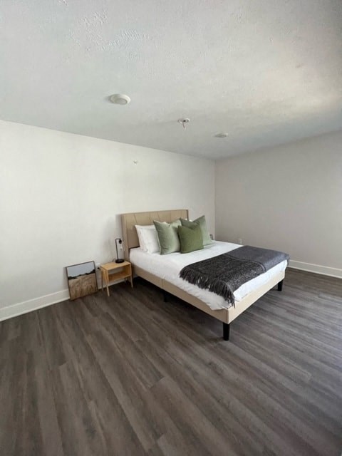 a bedroom with a bed and a wooden floor