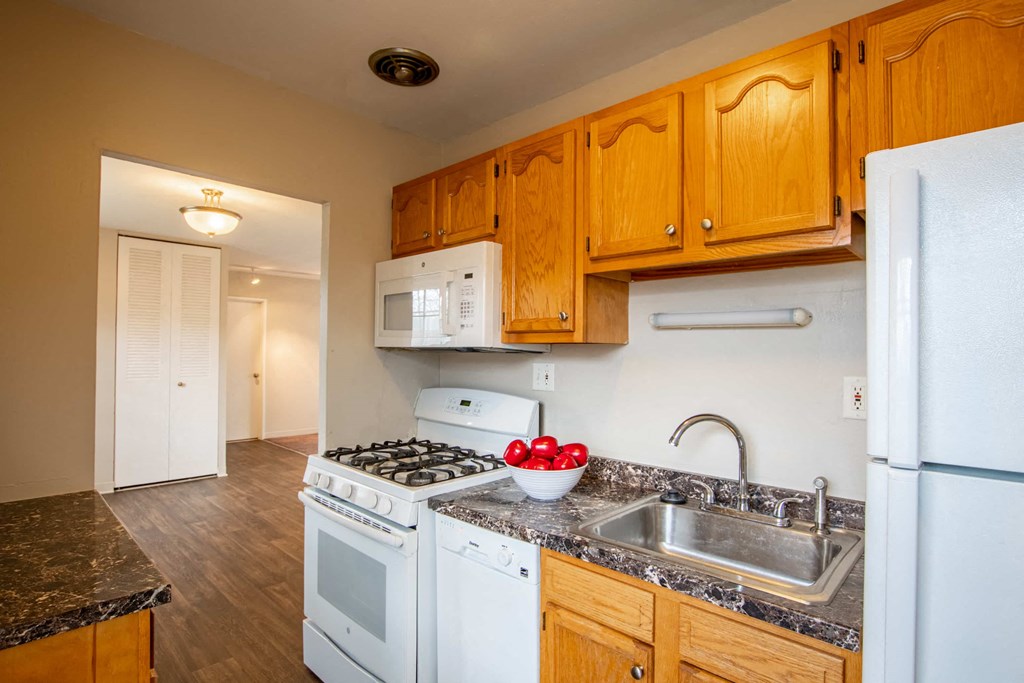 a kitchen with white appliances and wooden cabinets